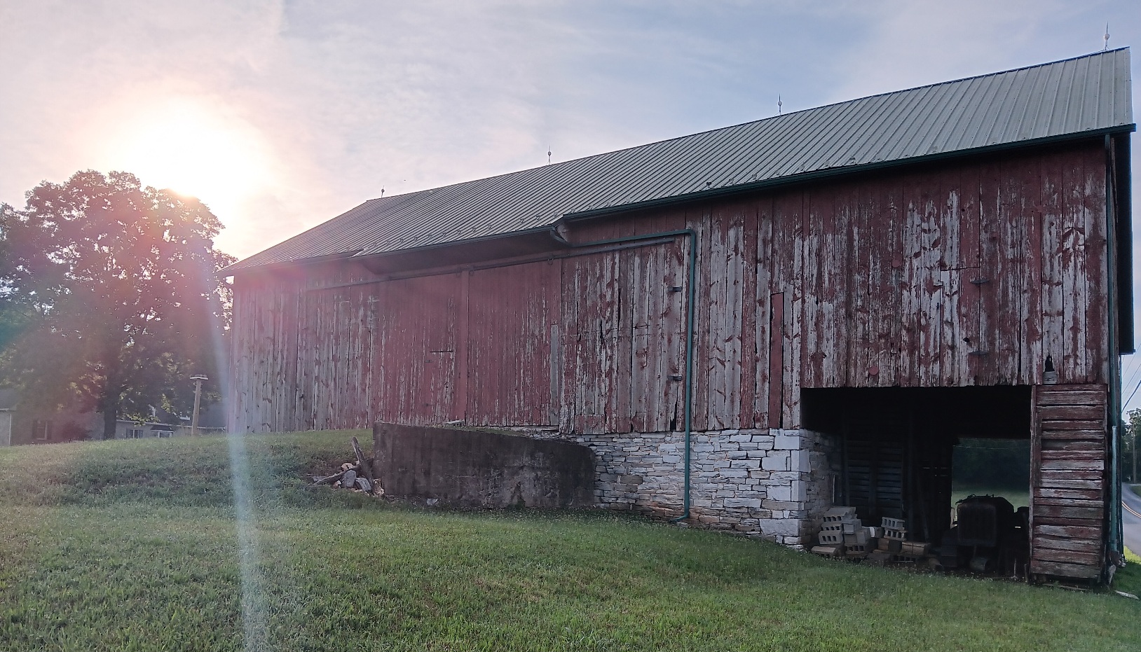 bank barn with faded paint and sun glint
